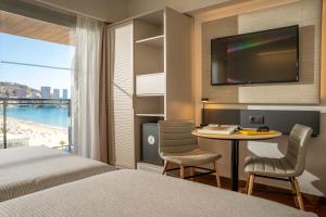 een hotelkamer met een bed, een bureau en een televisie bij INNSiDE by Meliá Costablanca - Adults recommended in Benidorm