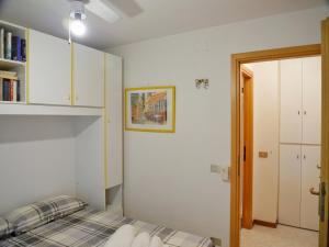 1 dormitorio con 1 cama en una habitación con armarios blancos en Cardellino, piccolo e accogliente dietro la spiaggia, en Grado