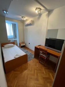 um quarto com uma cama e uma secretária com um computador em Perla Inn em Osijek