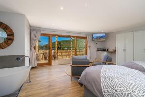 a bedroom with a tub and a bed and a bathroom at In Toto Retreat - Garden Route in Sedgefield