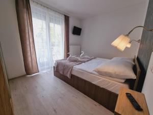 a bedroom with a bed with a lamp and a window at Andi Apartman in Siófok +18 photos
