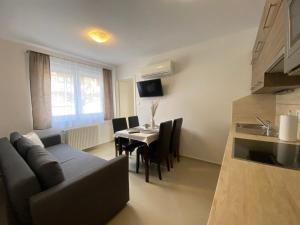 a living room with a couch and a table with chairs at Andi Apartman in Siófok