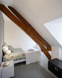 ein weißes Zimmer mit einem Bett und einer Treppe in der Unterkunft Panorama sur le Château de Carrouges in Carrouges