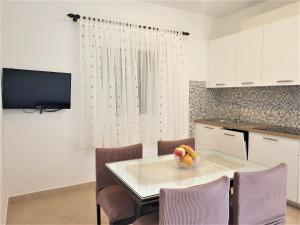 a kitchen with a table with a bowl of fruit on it at Apartments Nevenka P. in Šilo
