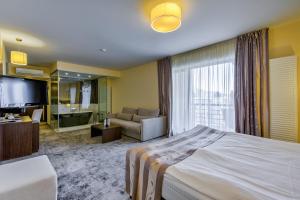 a hotel room with a large bed and a couch at Golden Time Hotel in Braşov +59 photos