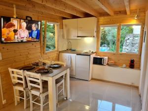 馬賽的住宿－Chalet Marseille hauteur，小屋内的厨房配有桌子和电视