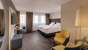 una camera d'albergo con letto e sedia di Hotel the YARD Bad Honnef a Bad Honnef am Rhein