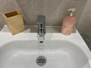 a sink with a soap dispenser and a bottle of soap at Number 10 Stunning Apartment, Fantastic Location! in Exmouth