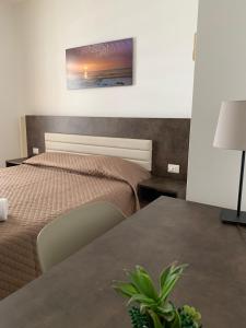 - une chambre avec un lit et une table avec une plante dans l'établissement Dea Seaview, à Cefalù