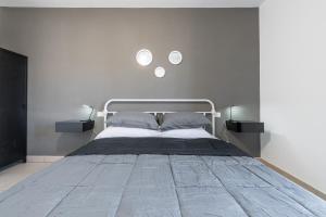 a bedroom with a large bed with two lights above it at Via Giardini 18 in Villasimius