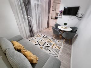 uma sala de estar com um sofá e uma mesa em RA Apartment - Ared em Oradea