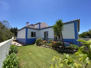 ein blau-weißes Haus mit einem Hof in der Unterkunft Villa Mochos Private Pool in Reguengo Grande