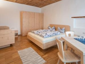1 dormitorio con cama, mesa y comedor en Vintlerhof, en Bresanona