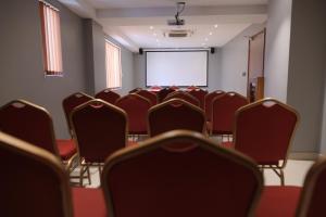 una habitación vacía con sillas y una pantalla de proyección en Hotel Grand Alleppey, en Alleppey