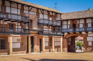 una fila de edificios con balcones y un patio en Casa Rural El Rincón del Valle, en San Carlos del Valle