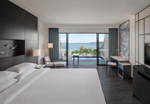 ein Schlafzimmer mit Bett und Blick auf das Meer in der Unterkunft Hyatt Regency Phuket Resort in Kamala Beach