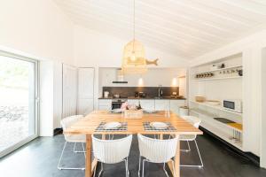 a kitchen and dining room with a wooden table and chairs at Casas da Prainha B in Santo Amaro