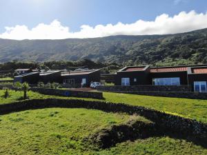 een huis op een heuvel met een groen veld bij Casas da Prainha B in Santo Amaro