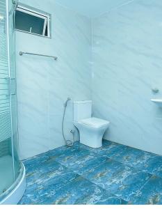 a white bathroom with a toilet and a sink at The Duchess Hotel in Matara