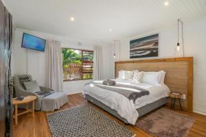 a bedroom with a large bed and a chair at In Toto Retreat - Garden Route in Sedgefield