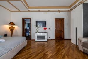 a bedroom with a bed and a tv and a couch at I Barcaioli in Giardini Naxos