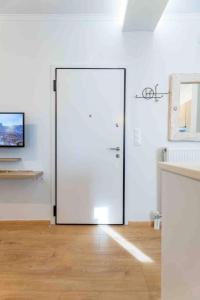 Una puerta blanca en una habitación con suelo de madera en Petit studio at Lenorman value for money en Atenas