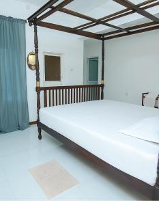 two beds in a room with a bed frame at The Duchess Hotel in Matara