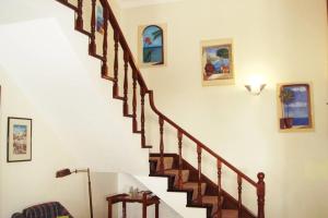 uma escada numa casa com pinturas na parede em Casa Oleandros na Lourinhã