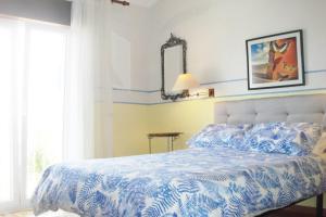 um quarto com uma cama com um edredão azul e branco em Casa Oleandros na Lourinhã