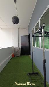 Casamea MOON (Shoplot) 2 Bedroom-Free Wifi & Washer في سيبو: غرفة مع سجادة خضراء وغرفة مع صالة ألعاب رياضية