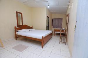 a bedroom with a bed and a chair in it at The Duchess Hotel in Matara