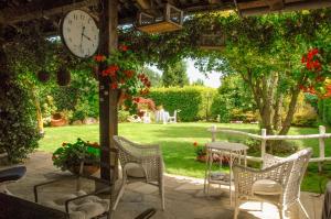 a patio with a table and chairs and a clock at Il Gomitolo in Biella