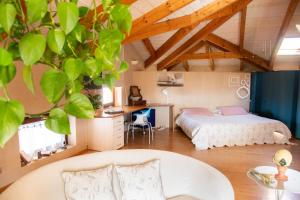 ein Schlafzimmer mit einem Bett, einem Schreibtisch und einem Tisch in der Unterkunft Il Gomitolo in Biella