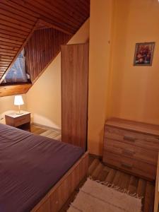 1 dormitorio con cama y techo de madera en Szilasi Vendégház, en Tüskevár