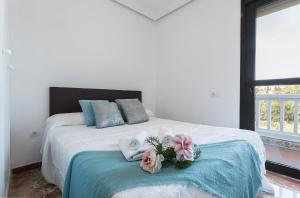 sypialnia z łóżkiem z ręcznikami i kwiatami w obiekcie Vistas Montealto Amplio 3 rooms 2 baños w mieście Jerez de la Frontera