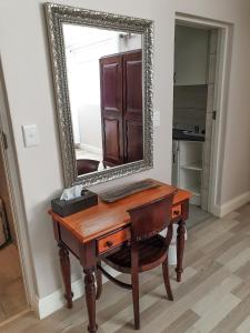 a wooden desk with a mirror on a wall at Elephant Country Guest House in The Crags