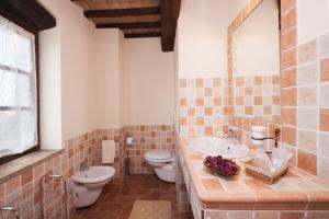 y baño con lavabo, aseo y espejo. en La casina di Bonucci, en Monte Santa Maria Tiberina