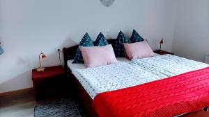 a bedroom with a bed with pink and blue pillows at Rooms Ravnik in Bled