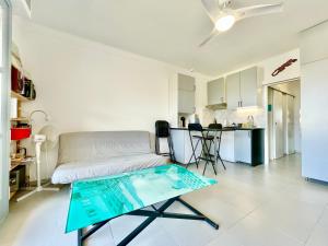 ein Wohnzimmer mit einem Sofa und einem Glastisch in der Unterkunft U Paradisu - Balcon - 100m mer - Parking - Climatisation in Propriano