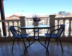 a glass table and two chairs on a balcony at Vesta in Thessaloniki