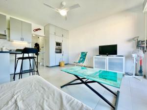 a living room with a glass table and a kitchen at U Paradisu - Balcon - 100m mer - Parking - Climatisation in Propriano