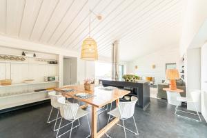 uma cozinha e sala de jantar com uma mesa de madeira e cadeiras em Casas da Prainha C em Companhia de Baixo