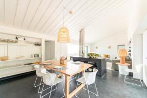 a kitchen and dining room with a wooden table and chairs at Casas da Prainha C in Canto da Areia