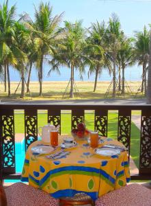 a table on a balcony with a view of the beach at Villa Espana in Sam Roi Yot