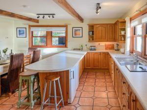 a kitchen with wooden cabinets and a large island at Innish - Uk38783 in Clachan