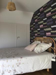 a bedroom with a bed with a wall of wine bottles at La Malvrais in Janzé