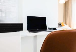 a laptop computer sitting on a desk with a television at Rahulihomes Lutakko in Jyväskylä +112 photos