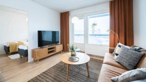 a living room with a couch and a tv at Rahulihomes Lutakko in Jyväskylä