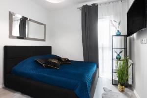 sypialnia z niebieskim łóżkiem i lustrem w obiekcie Margaret Apartment w Krakowie