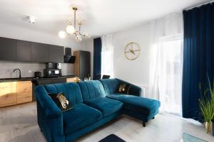 salon z niebieską kanapą i kuchnią w obiekcie Margaret Apartment w Krakowie